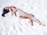 Suzie pulls down red bikini in sand